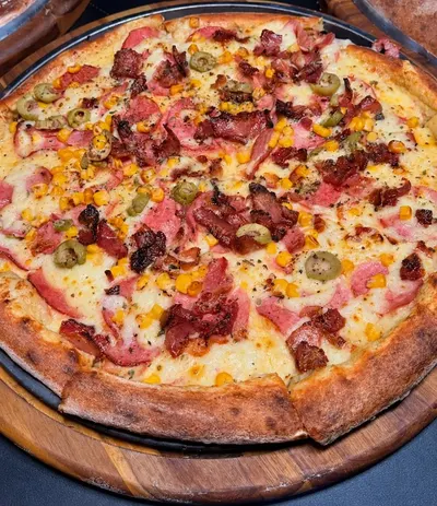 Pizza da Moriá com bacon, presunto, milho e azeitonas